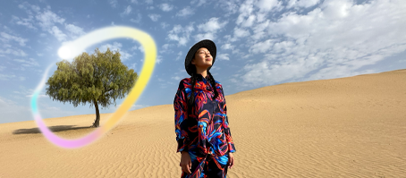 جهاز iPad Pro، الجزء الأمامي الخارجي من الشاشة مع خلفية ذات تدرّج باللونين الأزرق الداكن والأخضر تعرض عدة تطبيقات مفتوحة، يد تحمل قلم Apple Pro وتضع دائرة حول رسم يعرض ميزة عصا الصور السحرية في Apple Intelligence‏