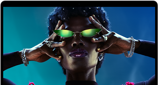 شاشة ملونة على MacBook Pro تُظهر شخصاً يتفاعل بحماس مع الجمهور في إحدى الحفلات، ما يبرز حيوية شاشة ريتنا ليكويد XDR‏ النابضة بالحياة