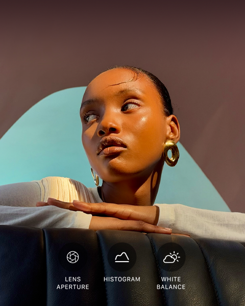 Close up portrait of a well-lit model with a colorful background, demonstrating the pro camera system's Pro controls UI: Aperture, Histogram, White Balance